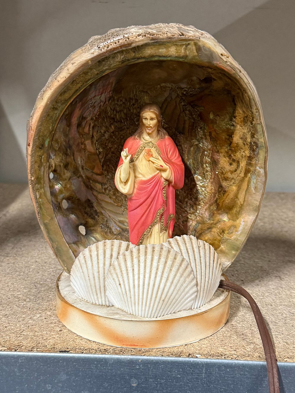 Lot 144: A mid-century abalone shell and Sacred Heart of Jesus lamp
