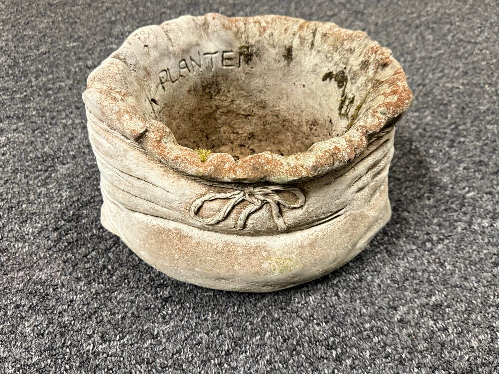 Lot 175: A weathered cast stone garden planter in sack form
