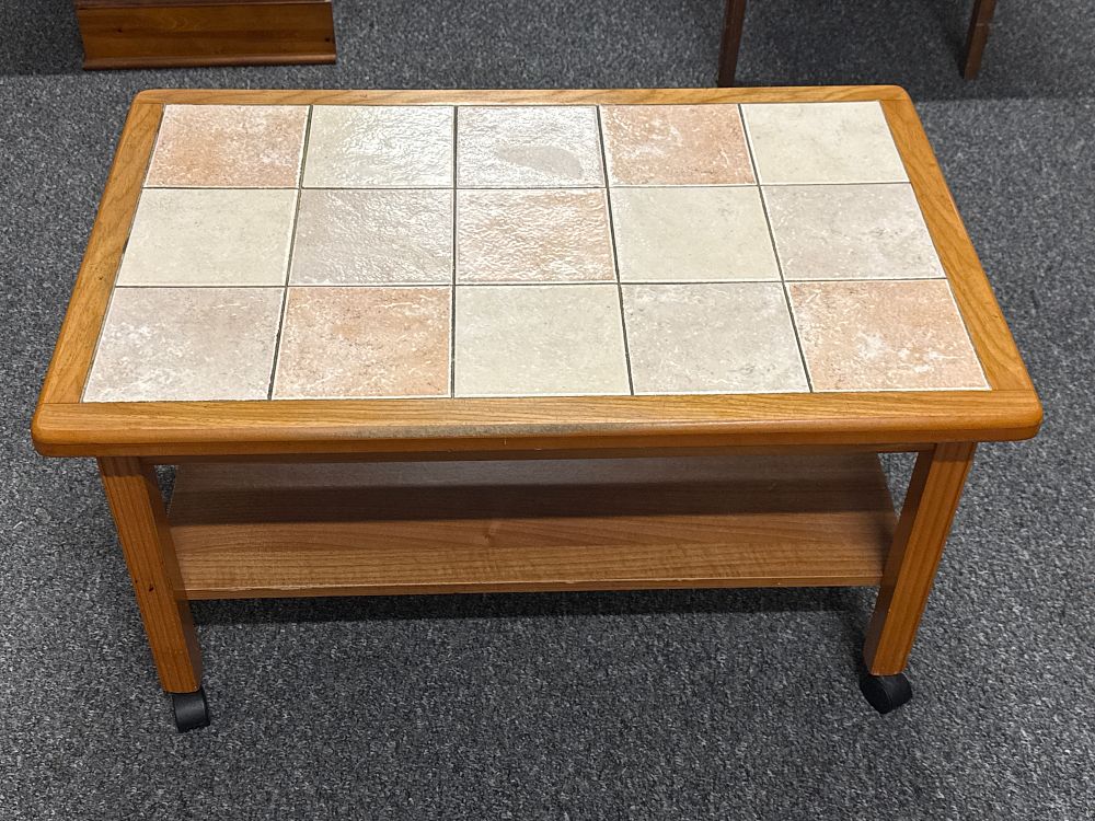Lot 233: Rectangular tiled top coffee table with lower shelf on castors