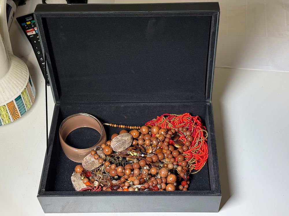 Lot 247: A collection of beaded costume jewellery in a floral glass-topped box