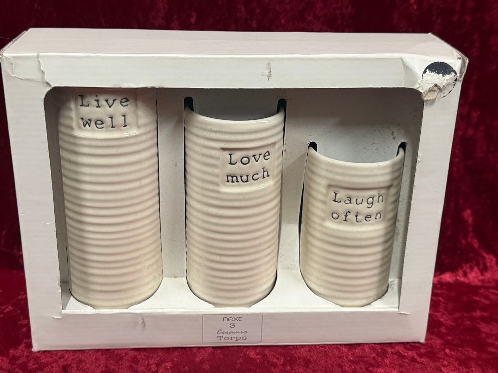 Lot 10: A set of three cream ceramic ribbed canisters by Next