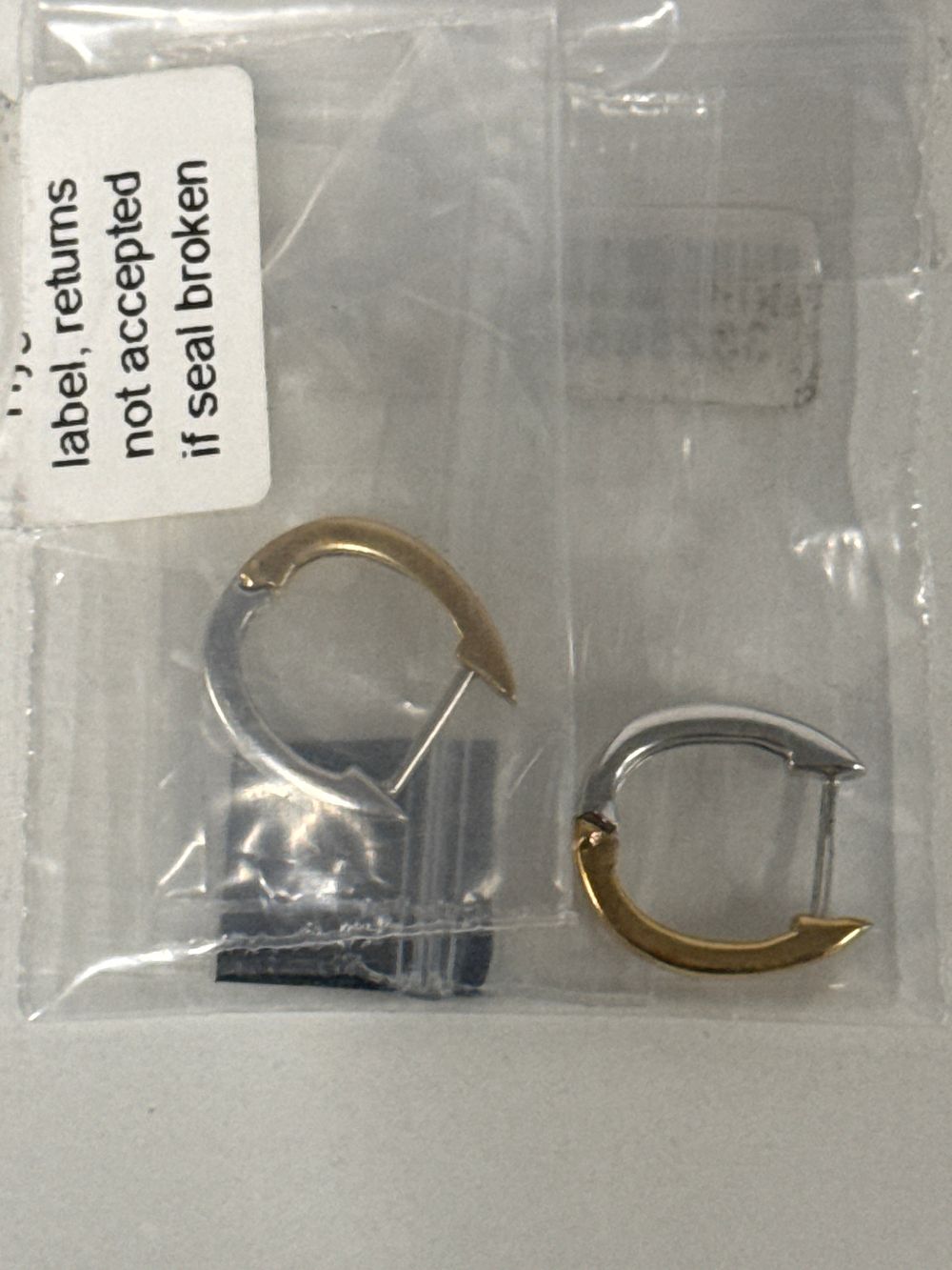 Lot 57: A pair of sterling silver two-tone huggie hoop earrings