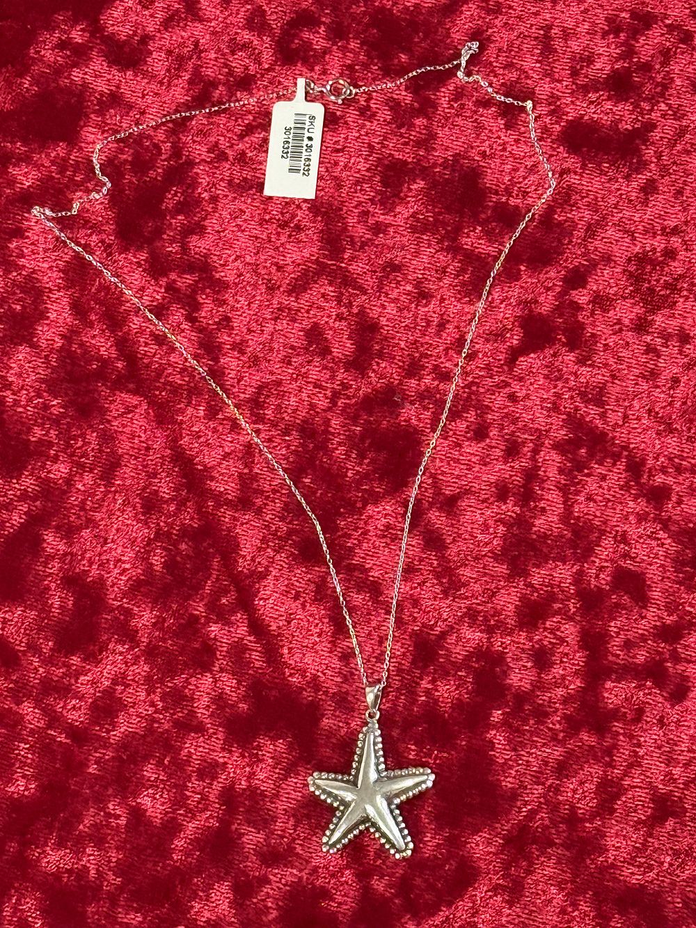 Lot 76: A large silver starfish pendant on a fine link chain