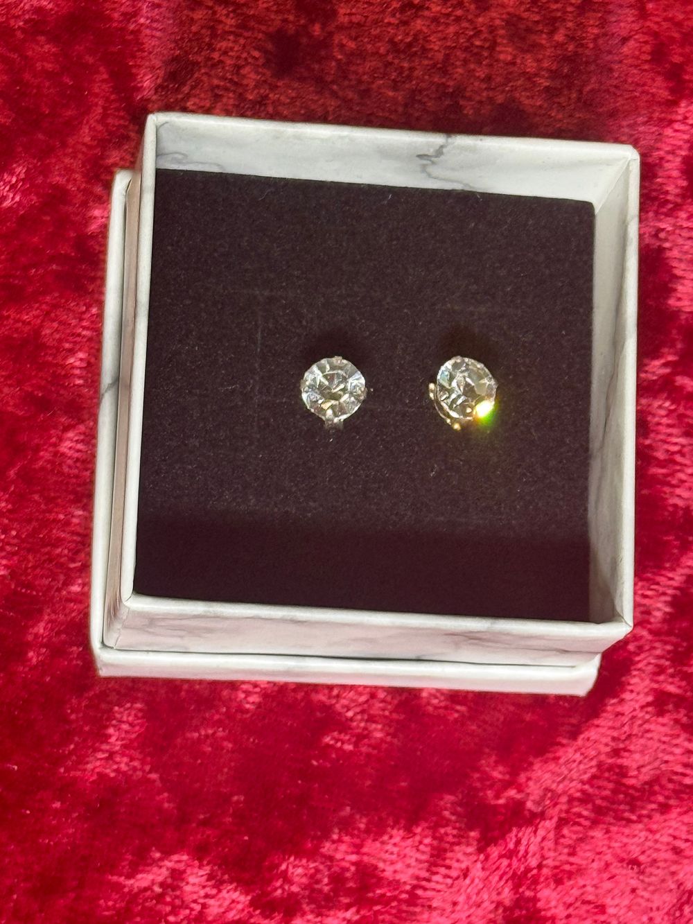 Lot 104: A pair of sterling silver round cut stud earrings