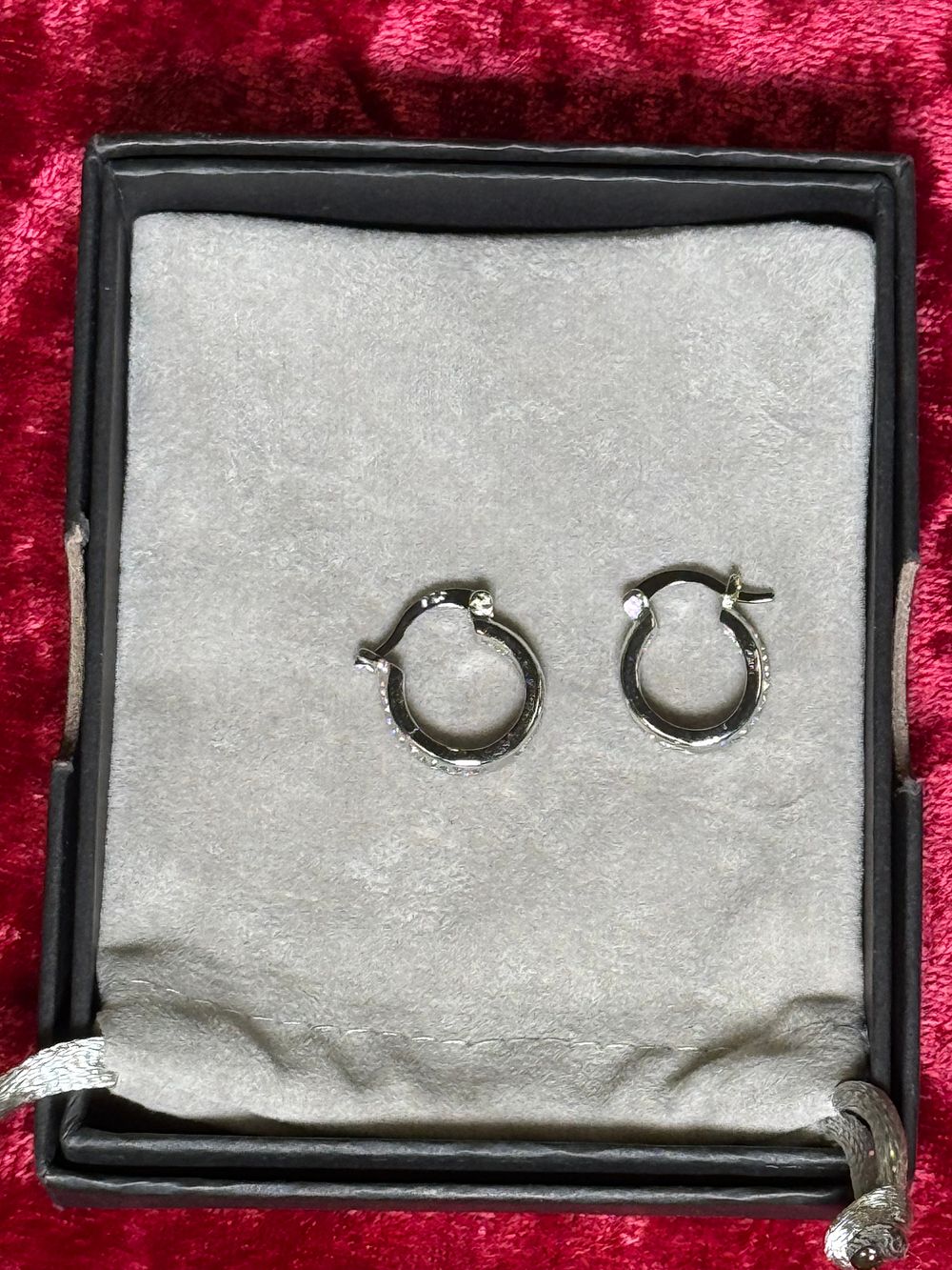 Lot 130: A pair of sterling silver stone set hoop earrings