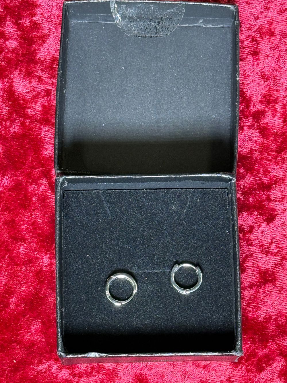 Lot 132: A pair of small sterling silver huggie hoop earrings