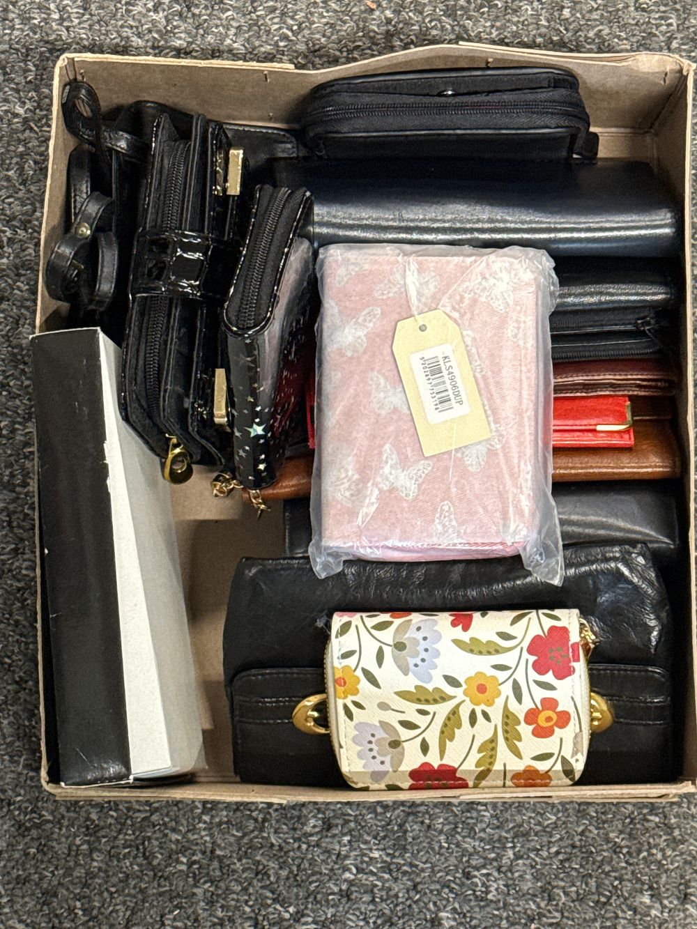 Lot 140: An assortment of approximately nine black, brown, and patterned wallets