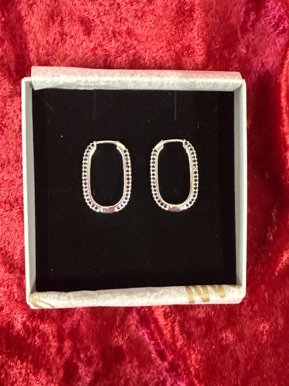 Lot 202: A pair of sterling silver oval pavé hoop earrings