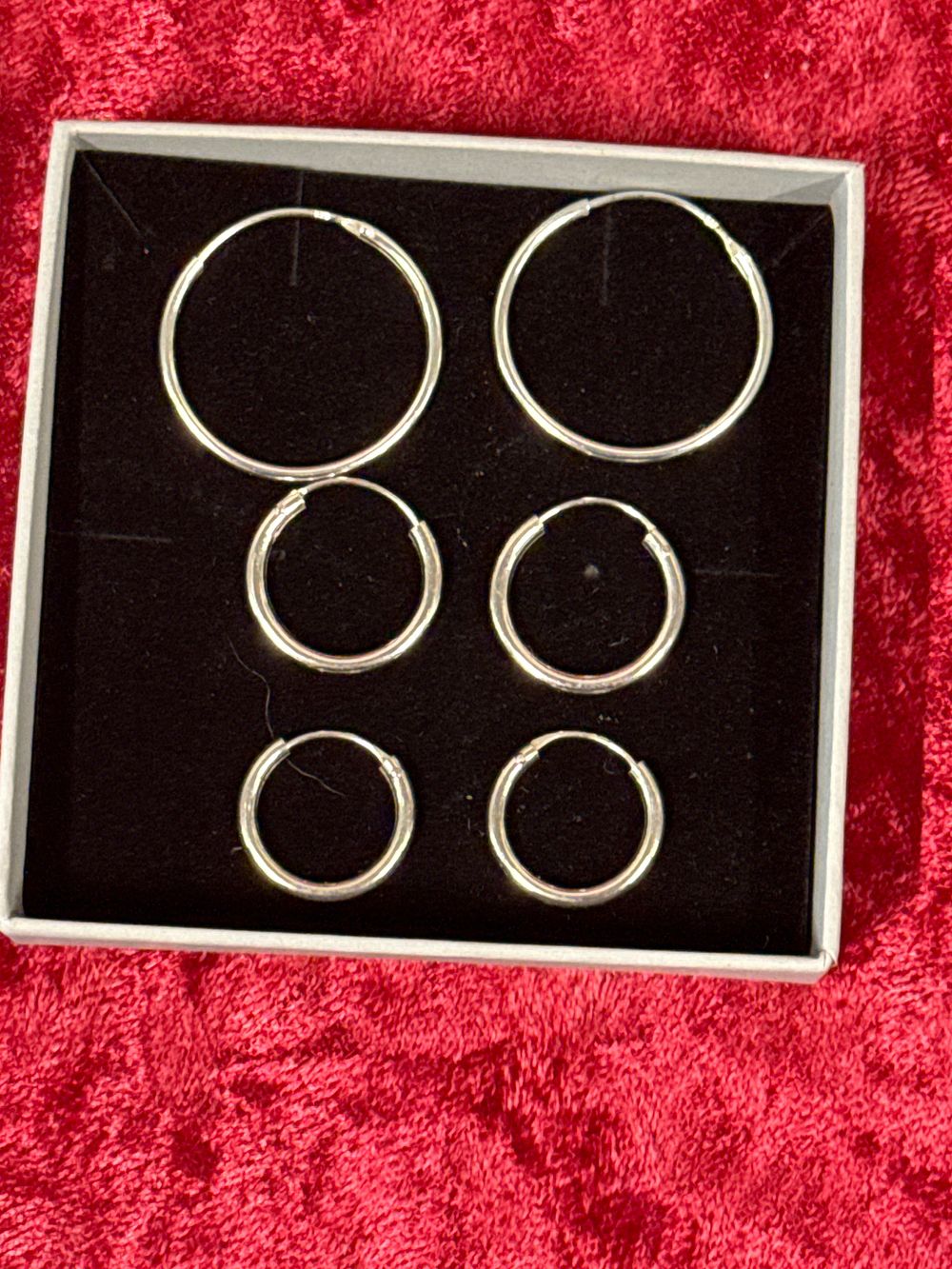 Lot 203: A set of three pairs of sterling silver hoop earrings