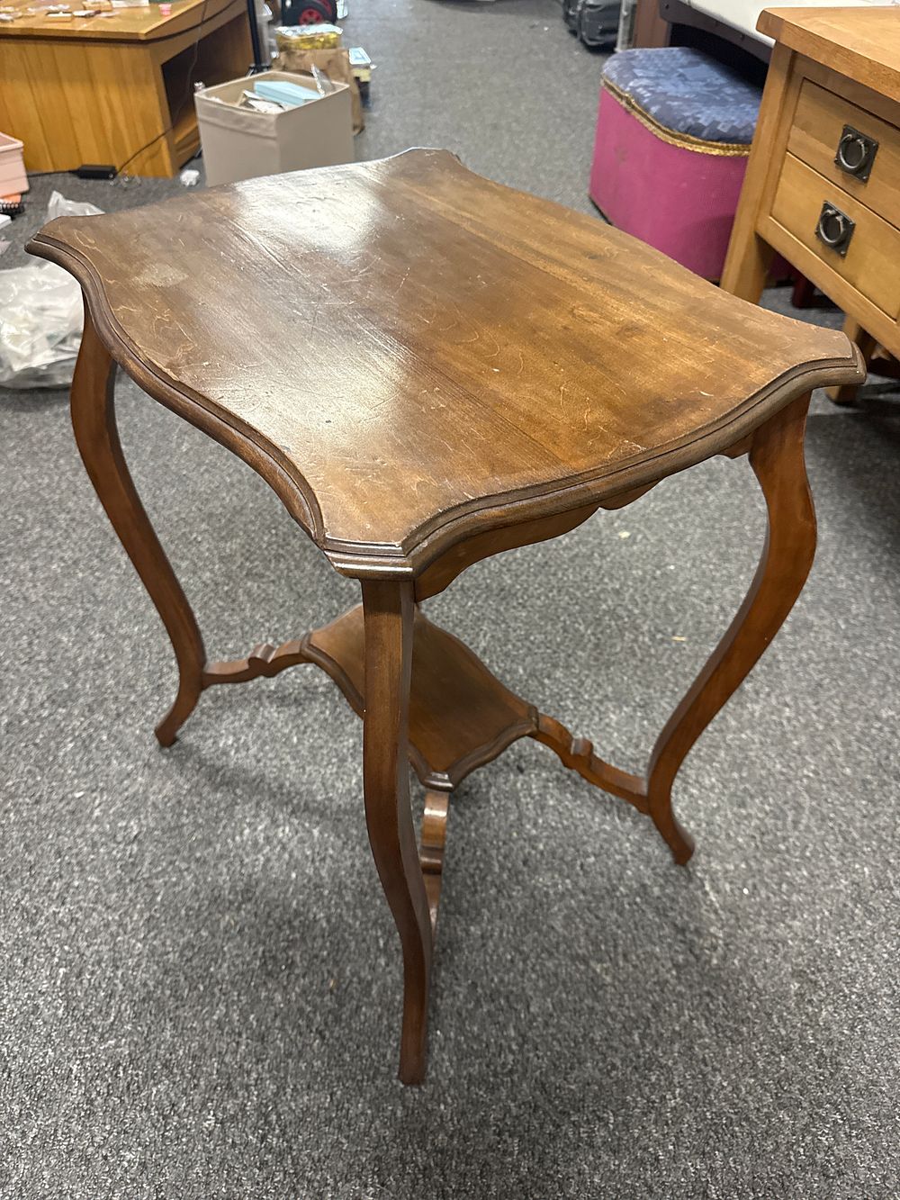 Lot 228: A mahogany two-tier serpentine occasional table in the Louis XV style