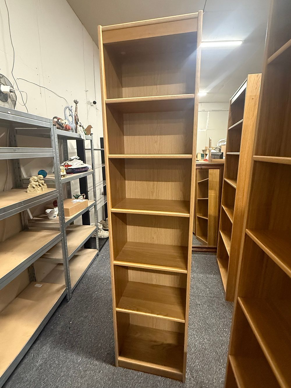 Lot 239: A contemporary tall light oak effect seven compartment bookcase
