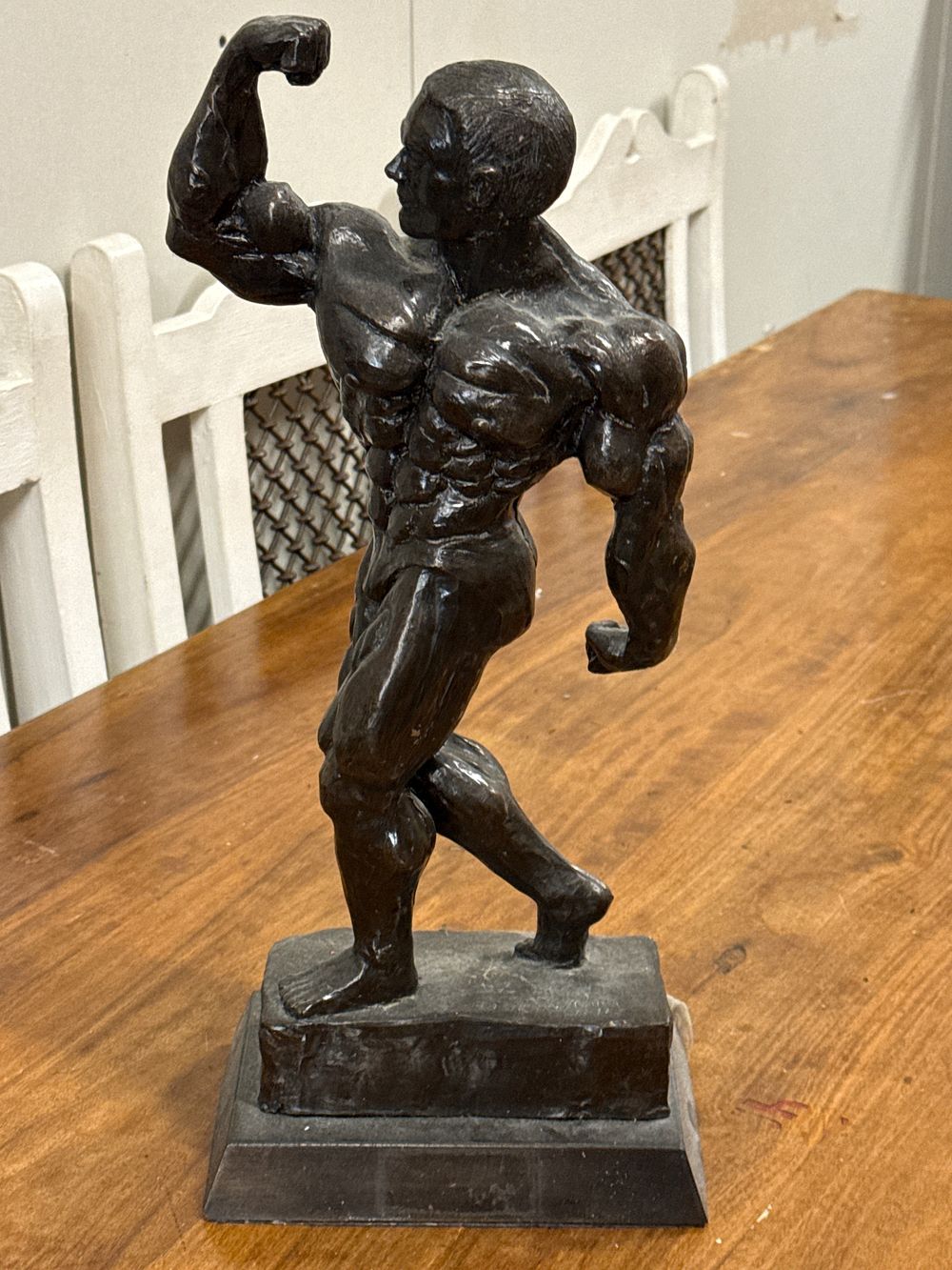 Lot 269: A contemporary dark patinated metal sculpture of a male bodybuilder