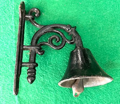 A Cast Iron Wall-Mounted Dinner Bell. This wall-mounted decorative or call bell is constructed 