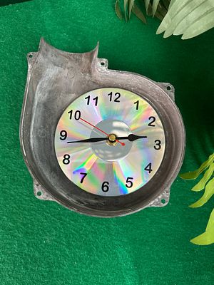 A Contemporary Upcycled Novelty Clock with Repurposed Cast Metal Housing and CD Face. This 