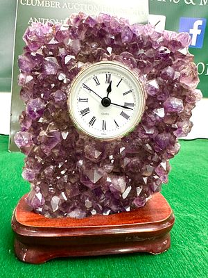 An Amethyst Crystal Cluster Table Clock on Wooden Base. A decorative table clock featuring a 