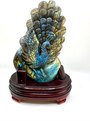 A Carved Labradorite Peacock Sculpture on Wooden Base. A hand-carved labradorite sculpture 
