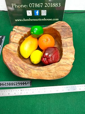 A Hand-Carved Mango Wood Bowl. A hand-carved mango wood bowl featuring an organic, rustic form 