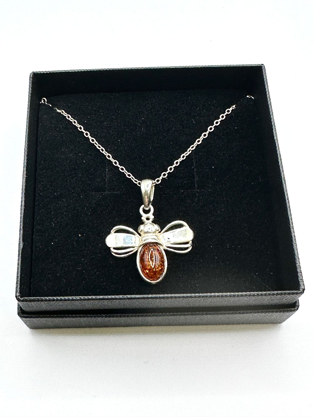 A Baltic Amber and 925 Silver Bee Pendant Necklace. A pendant necklace featuring a stylized bee 
