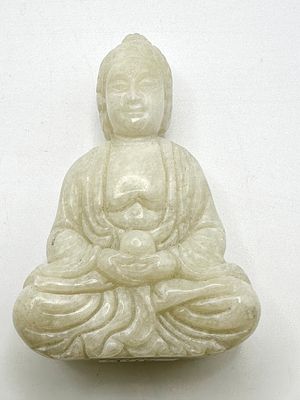 A Carved White Jade Figure of a Seated Buddha. A carved white marble figure of a seated Buddha 