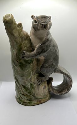 A Glazed Ceramic Figurine of a Squirrel on a Tree Trunk Bud Vase. A glazed ceramic figurine of a 