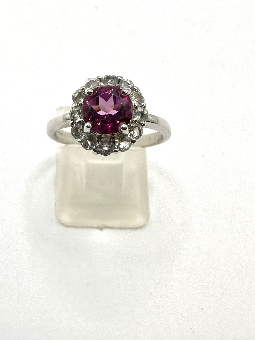 Lot 103: A 9 Carat White Gold Purple Garnet and Clear Gemstone Halo Cluster Ring