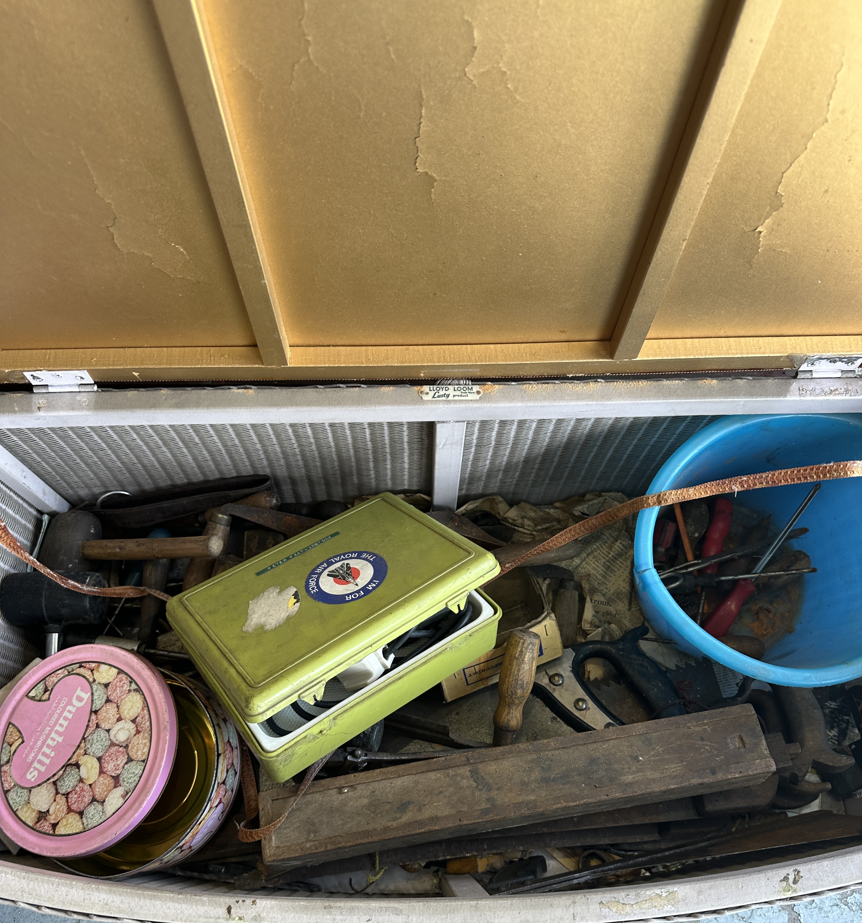 A Lloyd Loom Lusty Woven Ottoman with an Assortment of Vintage Tools and Tins