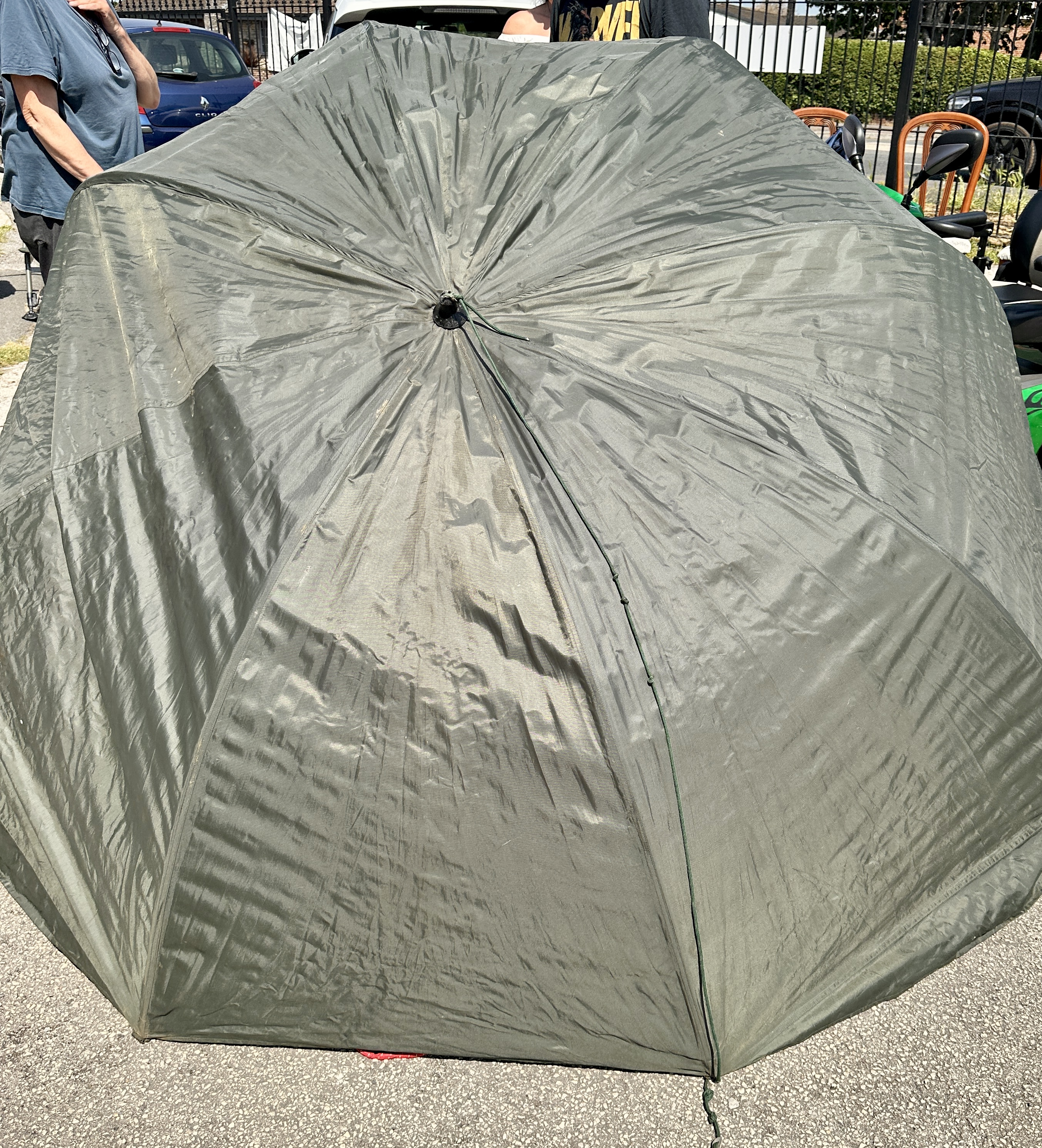 An olive green angling brolly fishing shelter