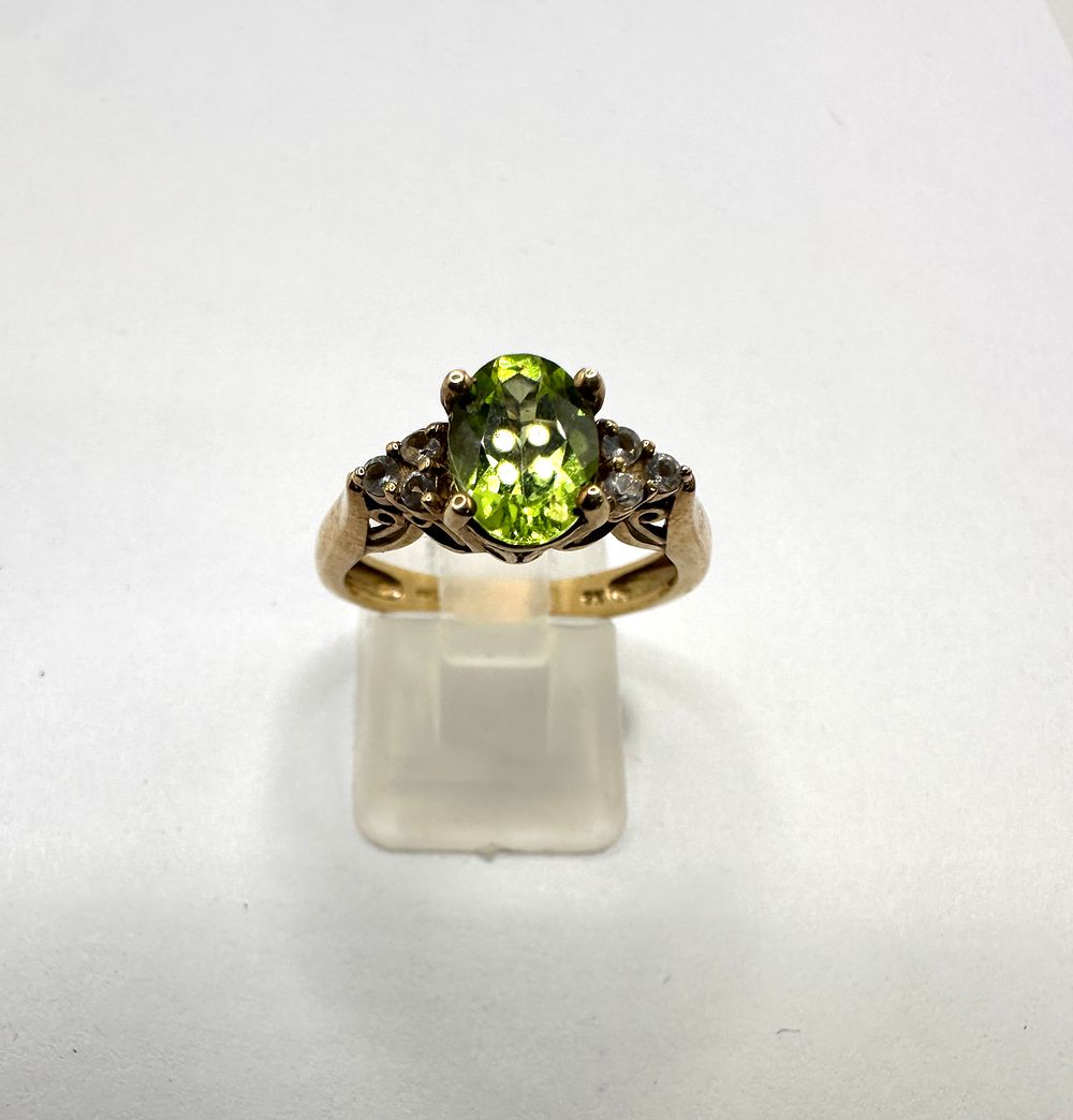 Lot 247: A 9 Carat Yellow Gold Peridot and Colourless Stone Cocktail Ring