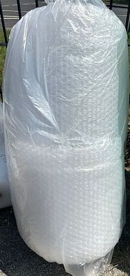 A large roll of clear plastic large-cell bubble wrap. A industrial-sized roll of clear 