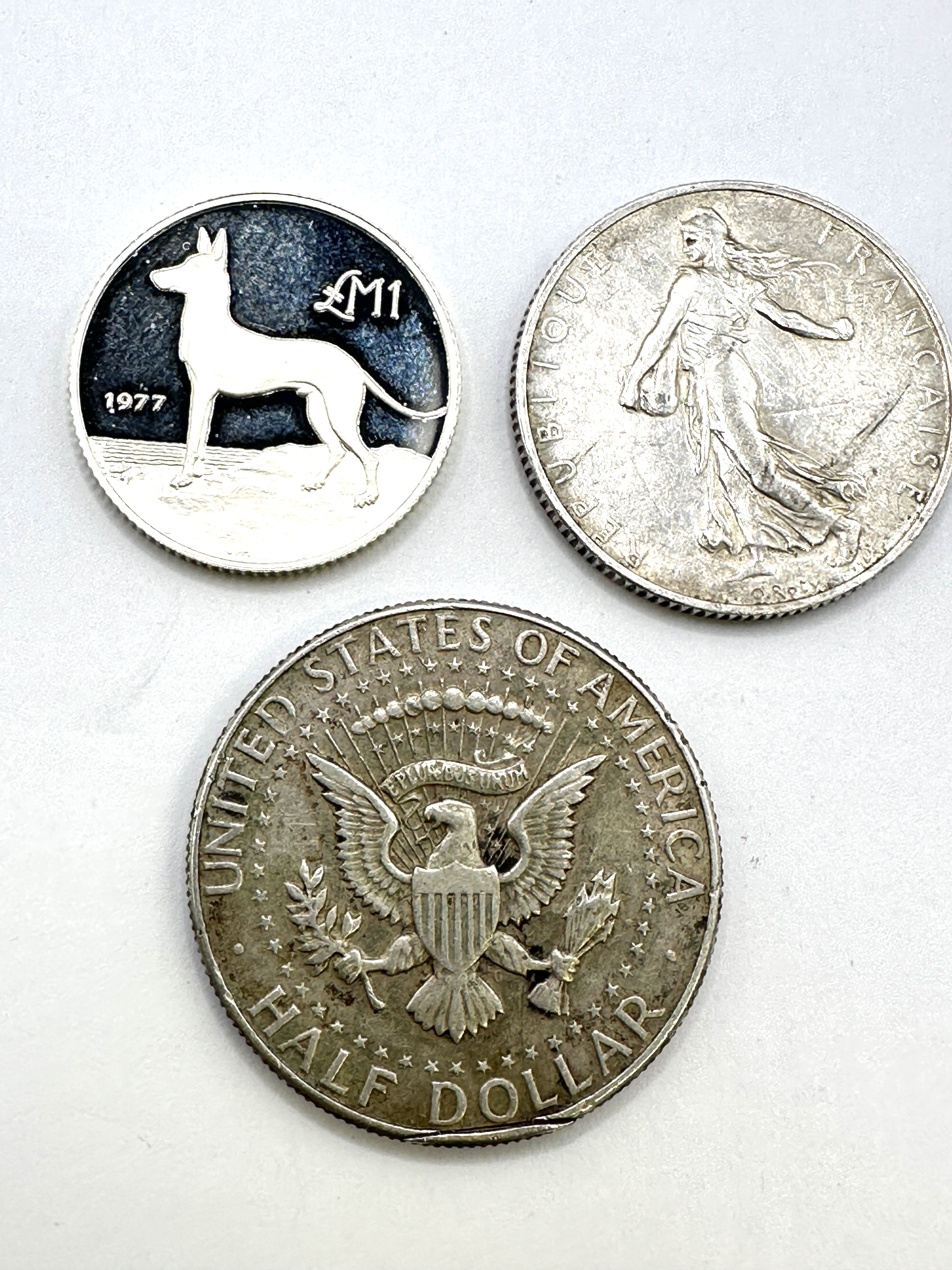 Three International Coins comprising 1965 US Kennedy Half Dollar, 1920 FR 2 Francs, and 1977 MT 1 Lira
