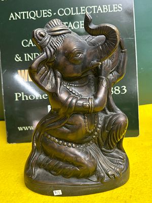 A Brass Sculpture of a Reclining Bull-Headed Figure. A cast brass sculpture depicting a 
