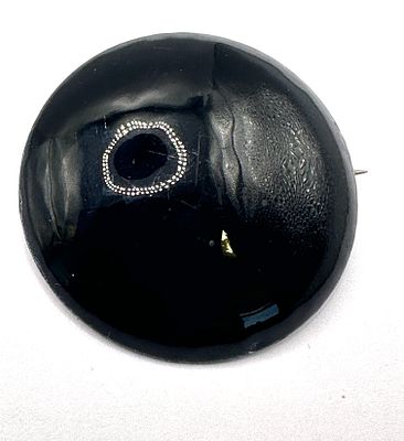 A Sterling Silver and Iris Obsidian Brooch. A circular domed brooch featuring a black iris 