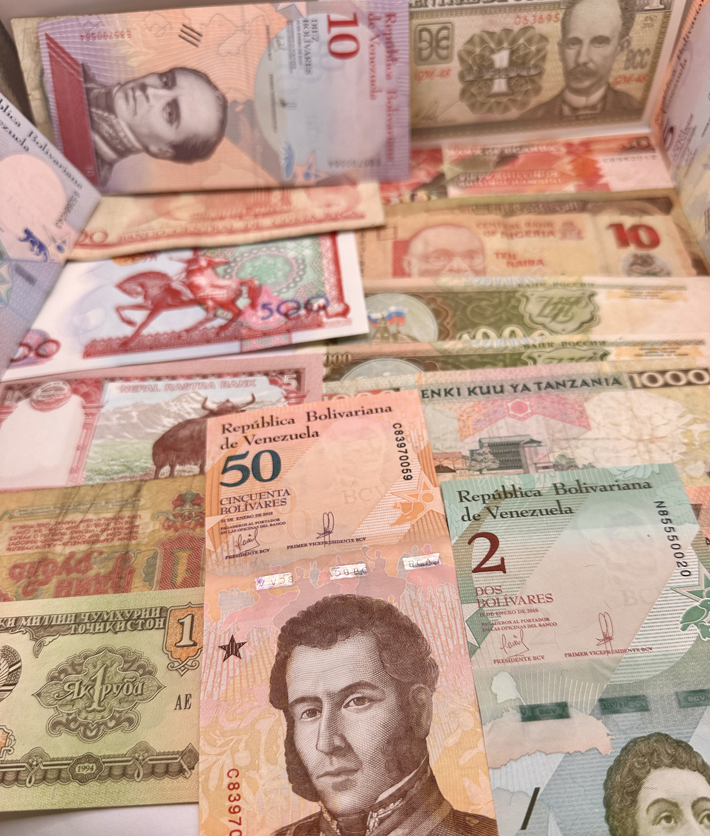 A Collection of World Banknotes Including VE, CU, NG, TZ, RU, and TJ