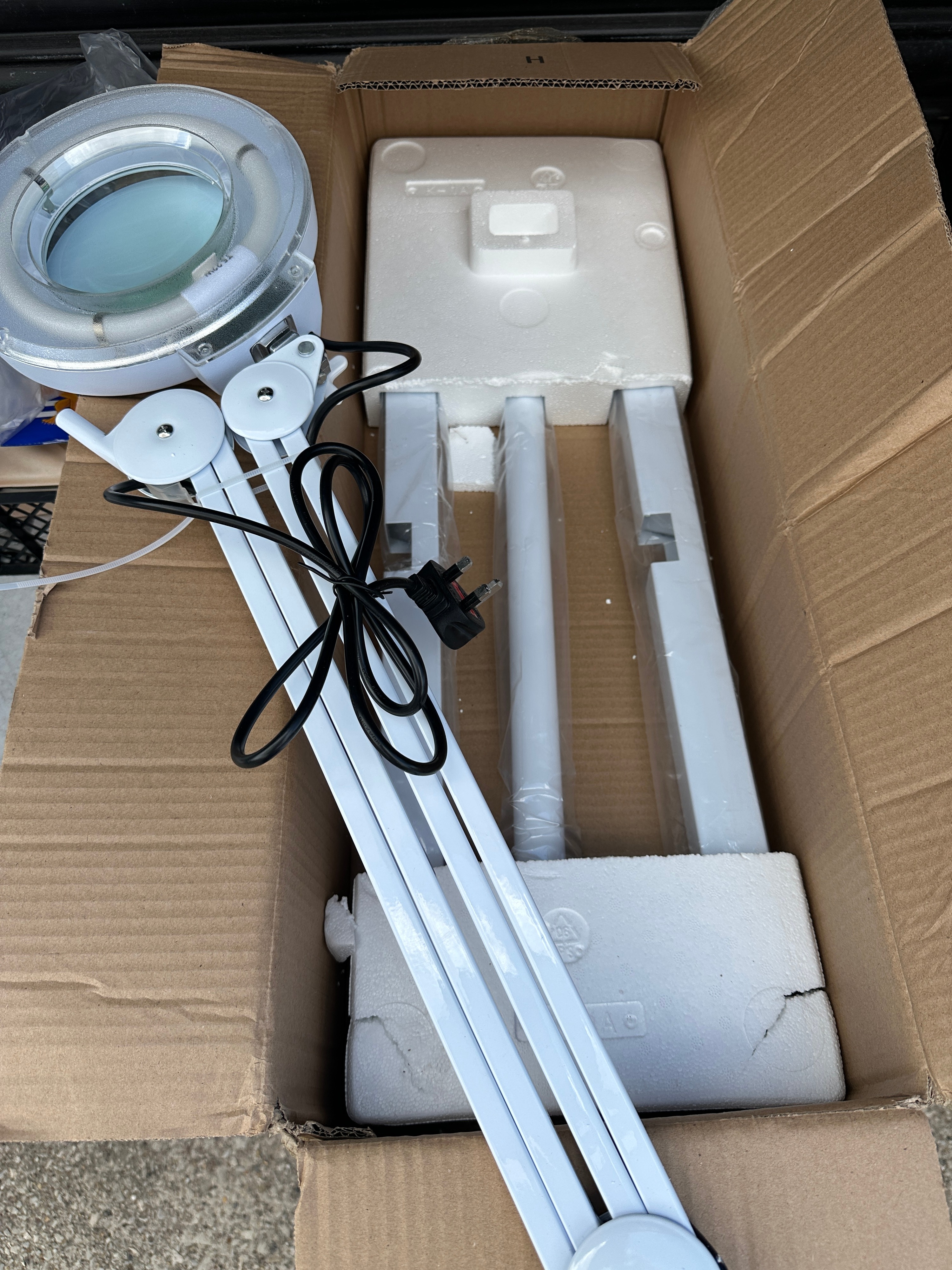 A Floor-Standing Magnifying Lamp with Articulated Arm and Wheeled Base