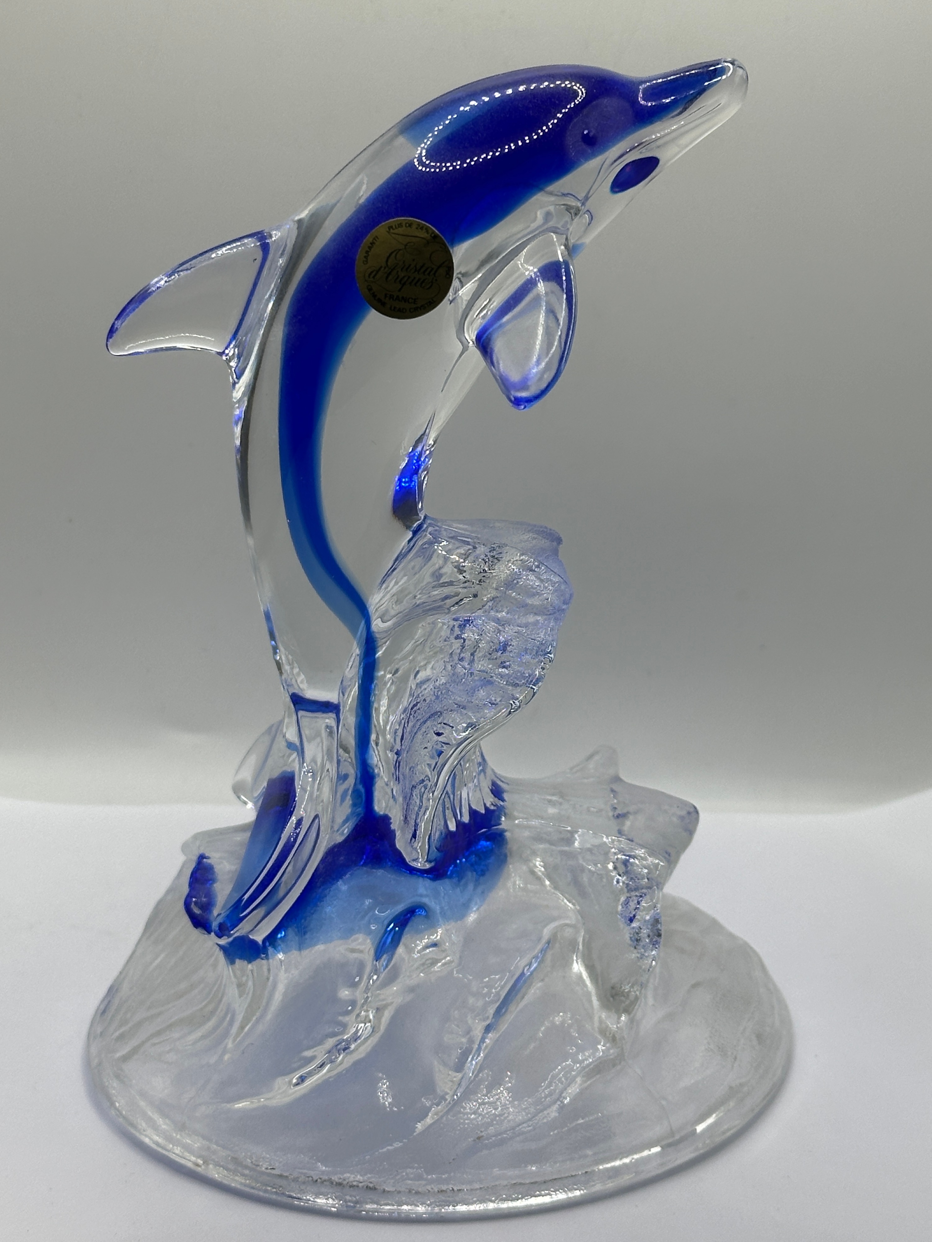 A French Lead Crystal Dolphin Figurine, featuring a blue core and wave base