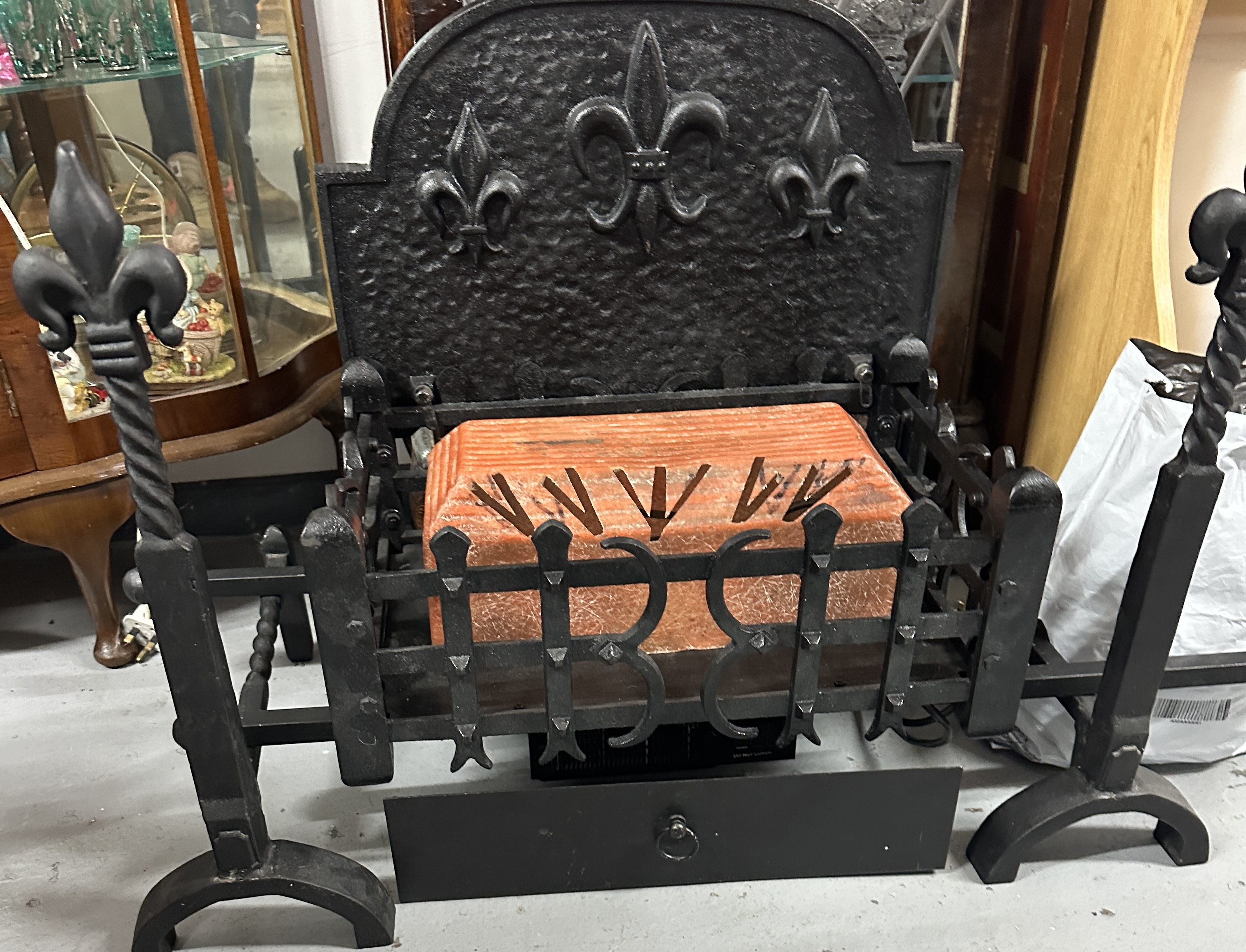 An Electric Fire Basket, featuring integrated andirons and fleur-de-lis motifs