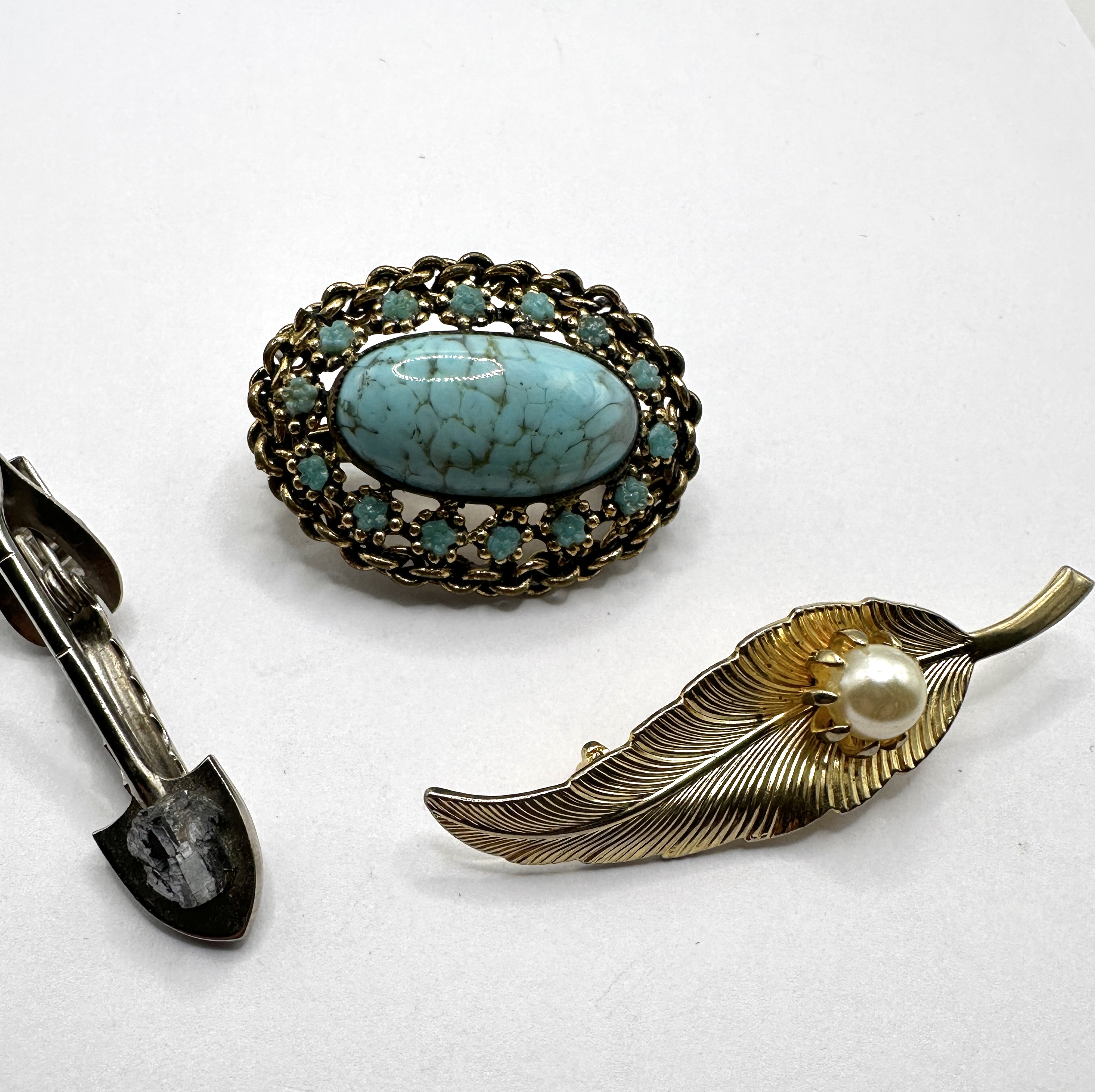 A Trio of Metal Brooches and Pins