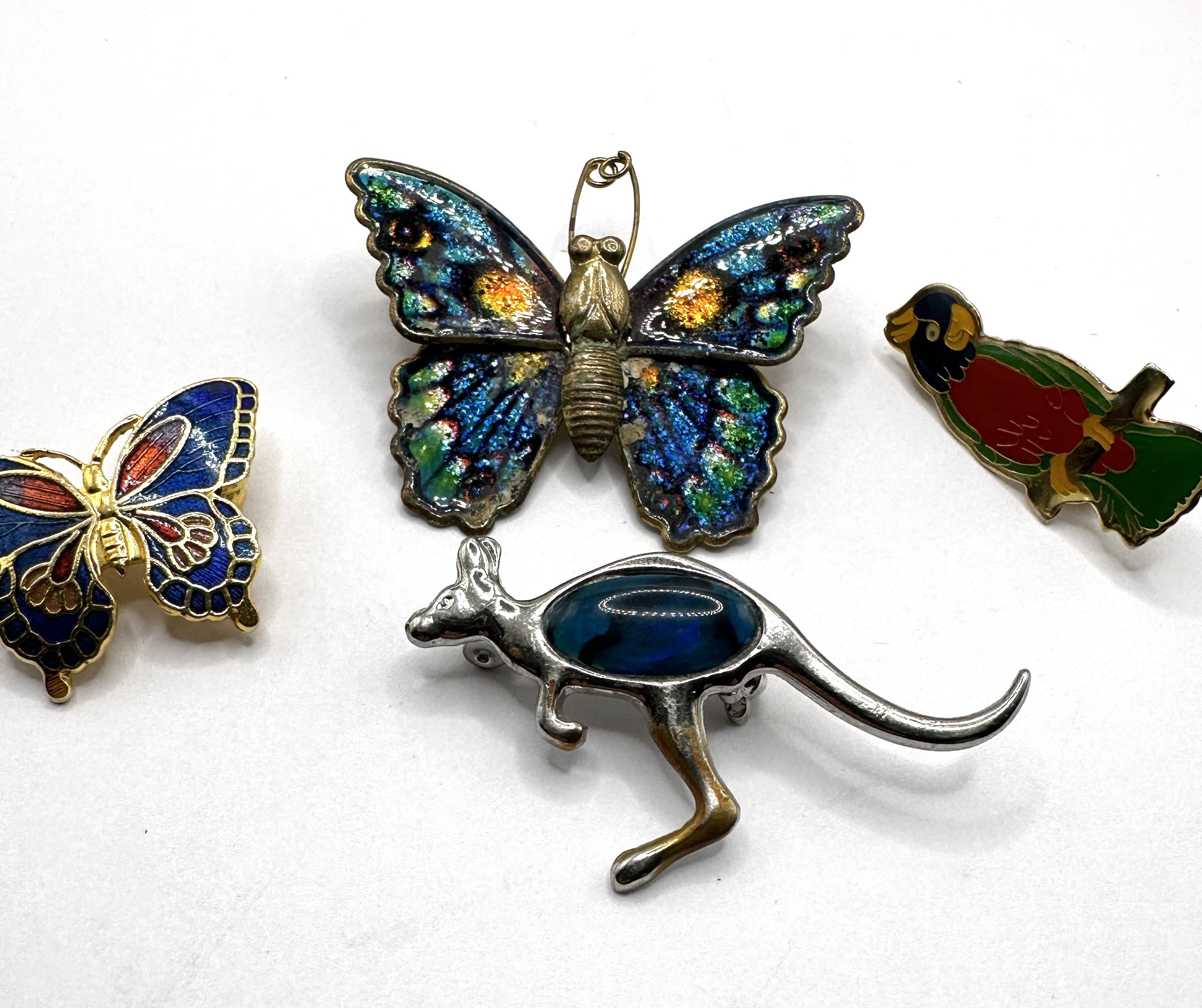 An Assortment of Enamel and Stone Set Metal Brooches