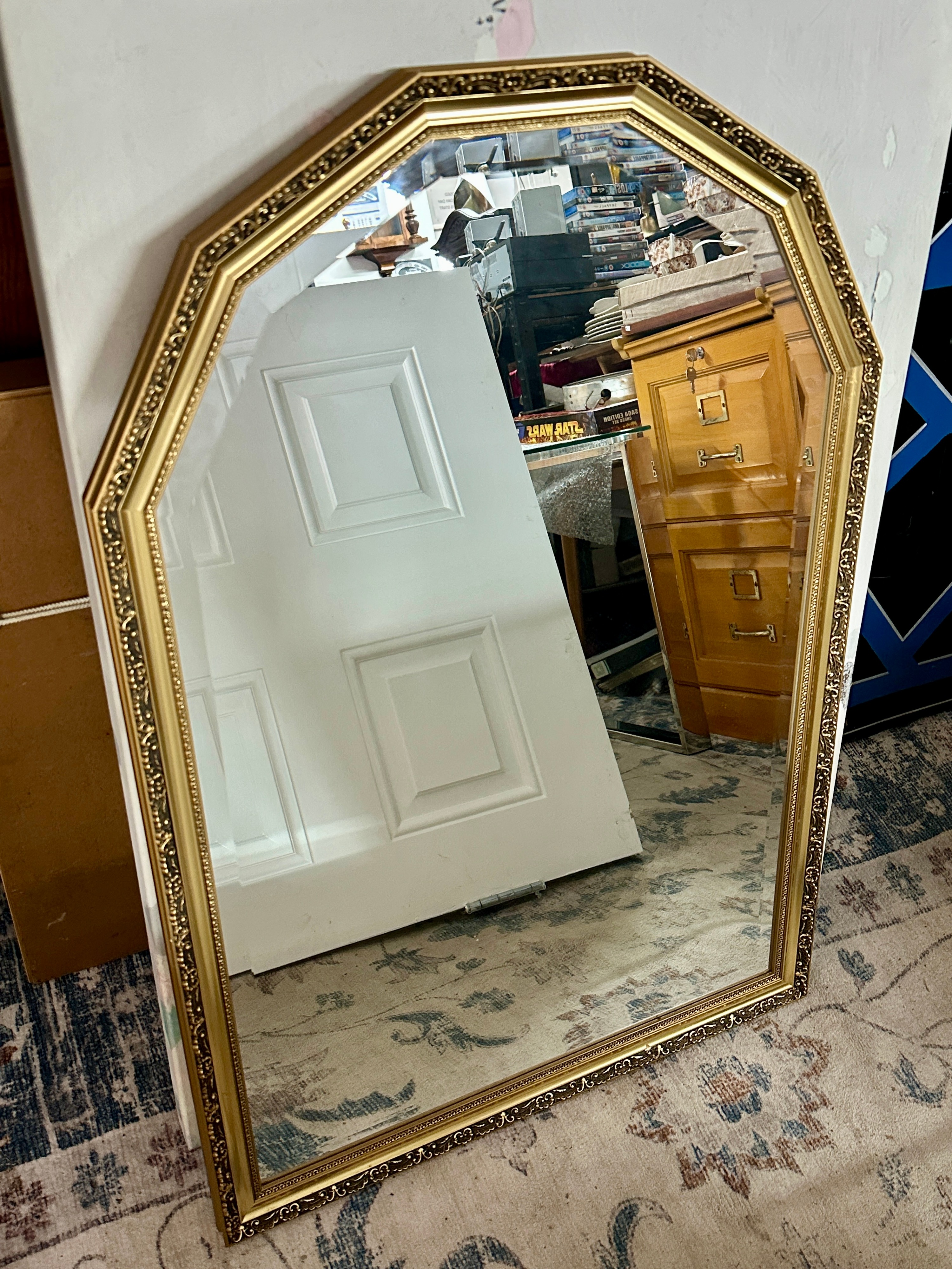 An Arched Wall Mirror with an Ornate Embossed Frame