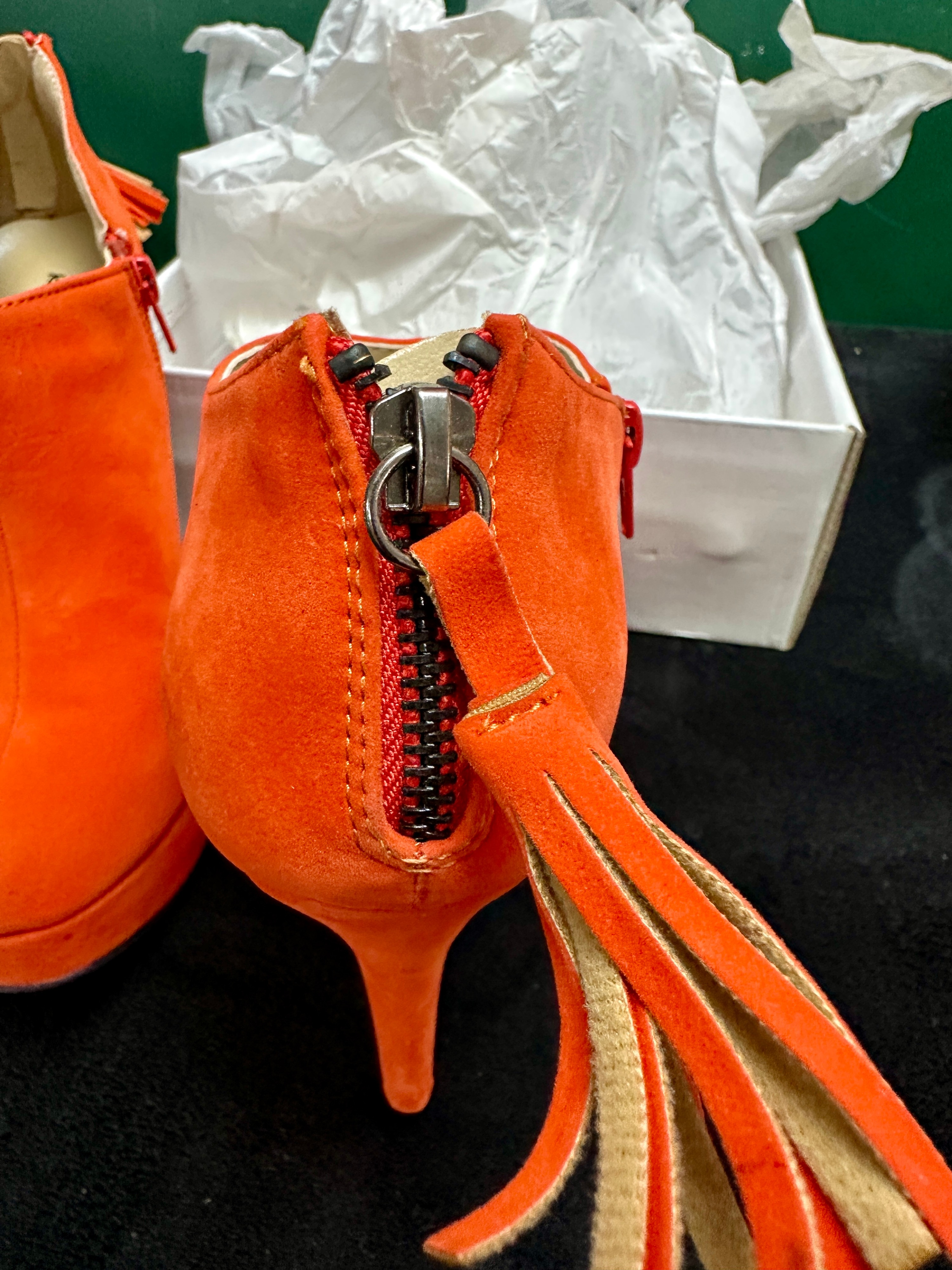 A Pair of Orange Platform Ankle Booties With Tassel Detail