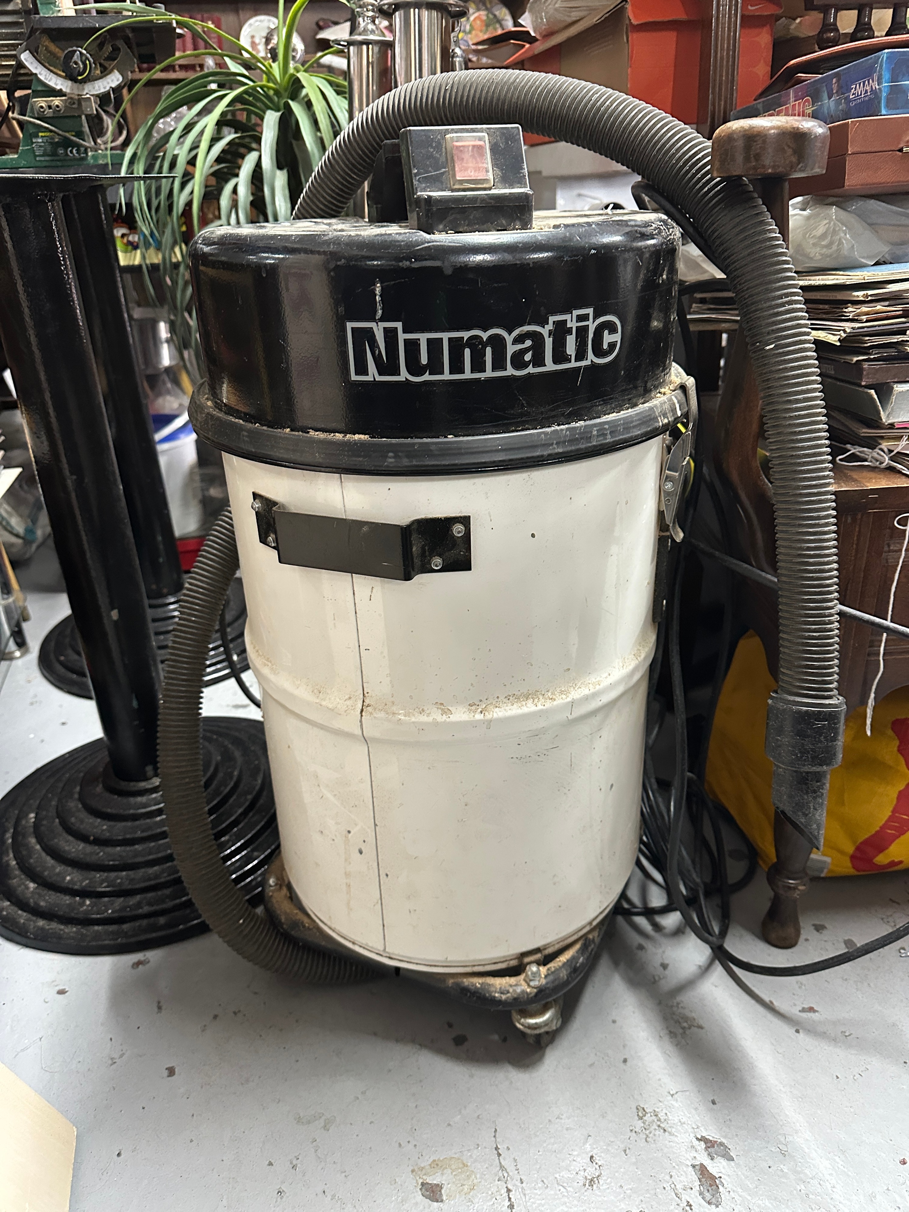 A Numatic Commercial Canister Vacuum Cleaner With Crevice Tool Attachment