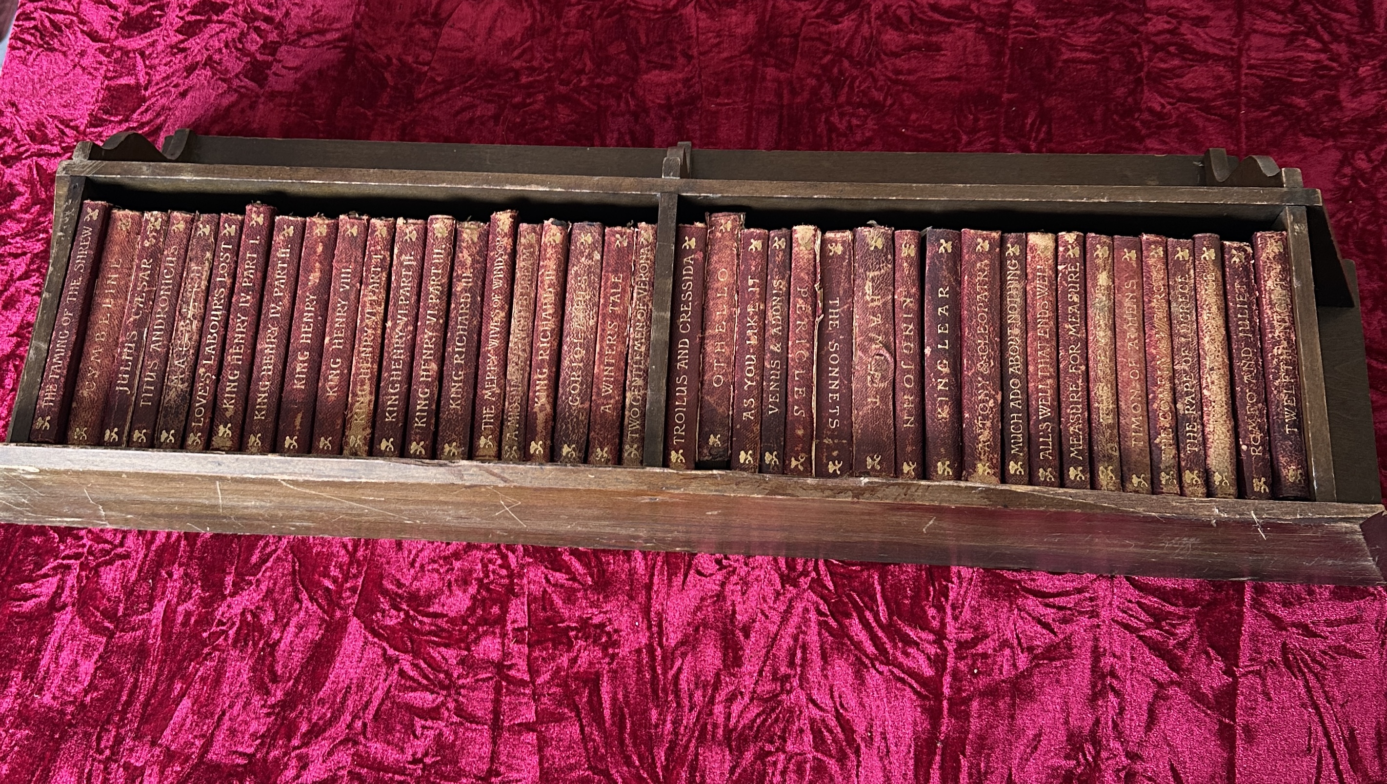 A Collection of Shakespeare Miniature Volumes in a Tiered Wooden Shelf
