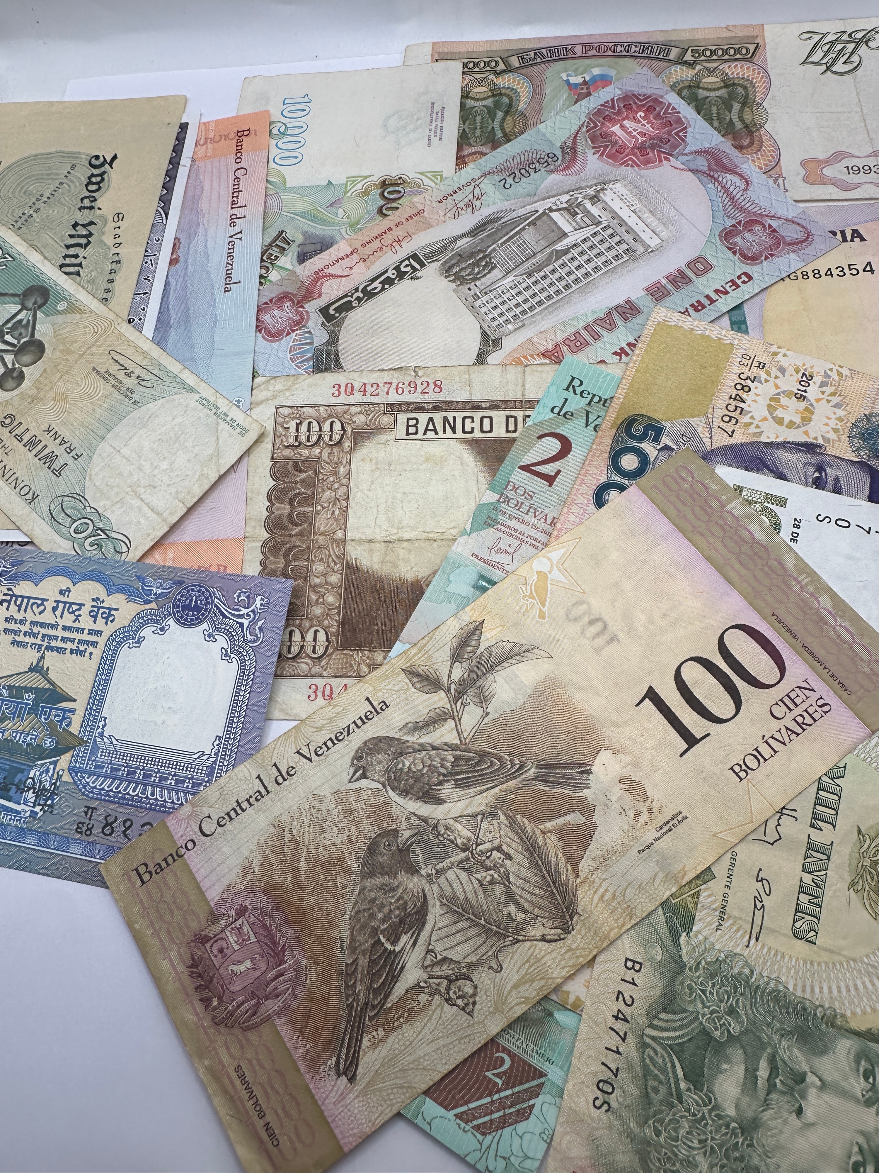A Collection of International Banknotes including Venezuela, Nigeria, and Peru