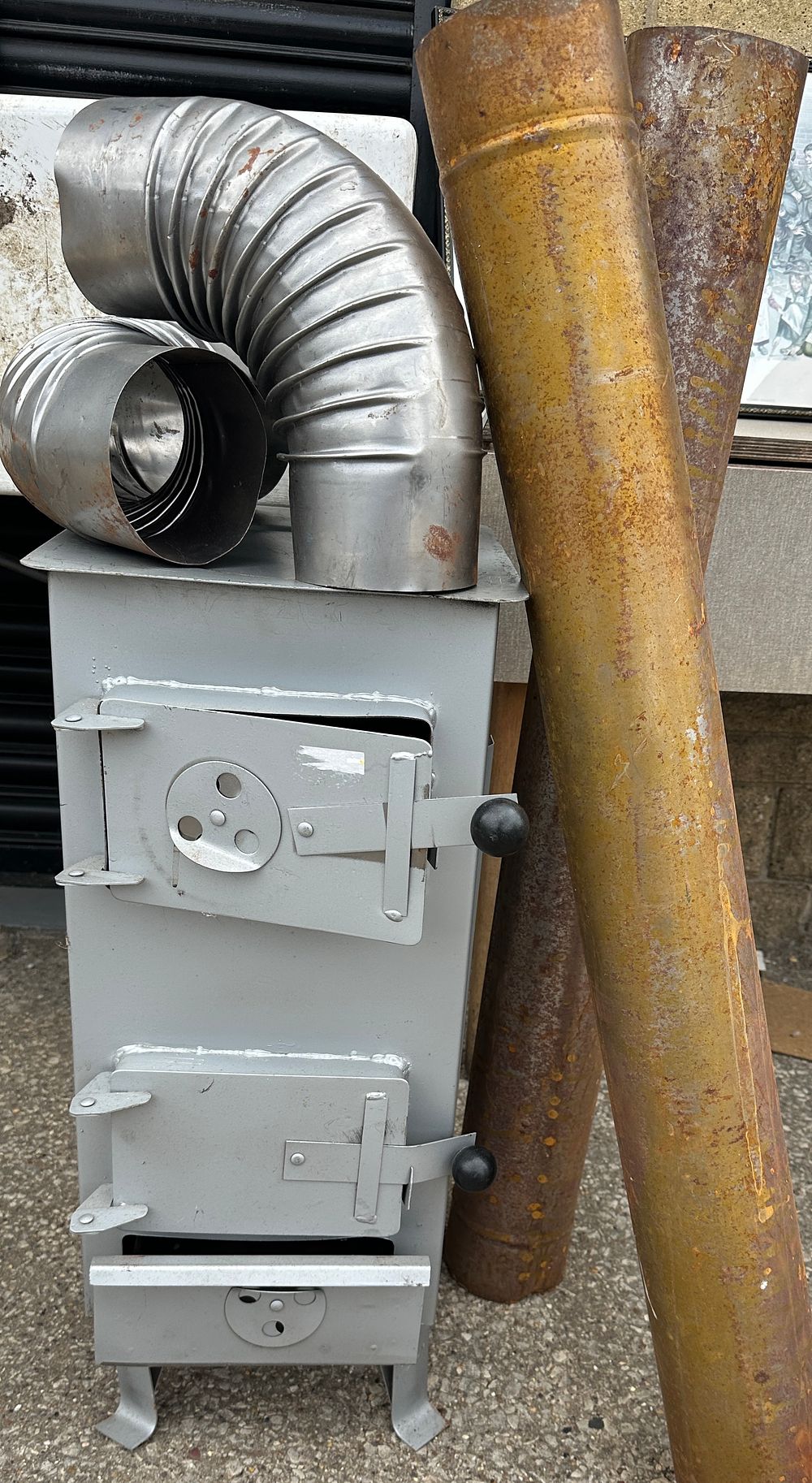 Lot 503: A Portable Metal Wood Burning Stove with Flue Components