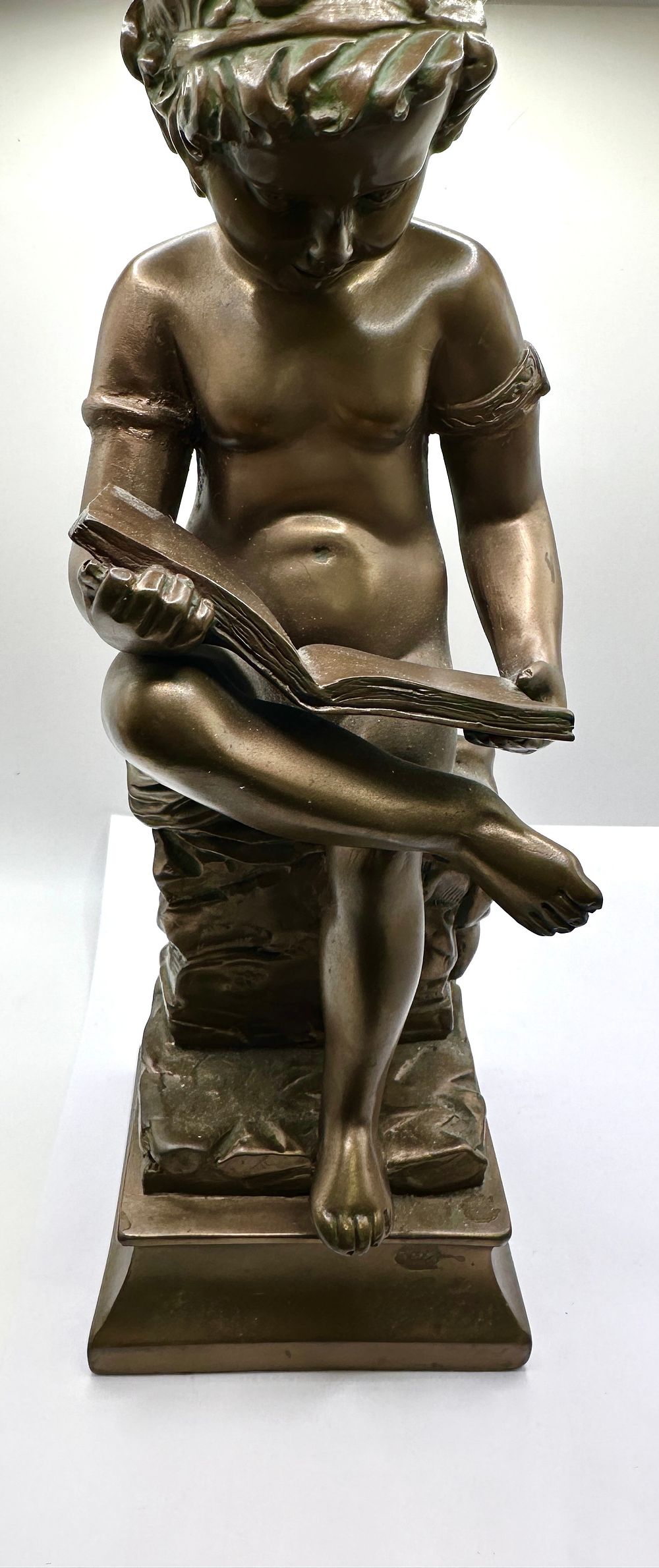 Lot 552: A Seated Figure of a Child Reading a Book