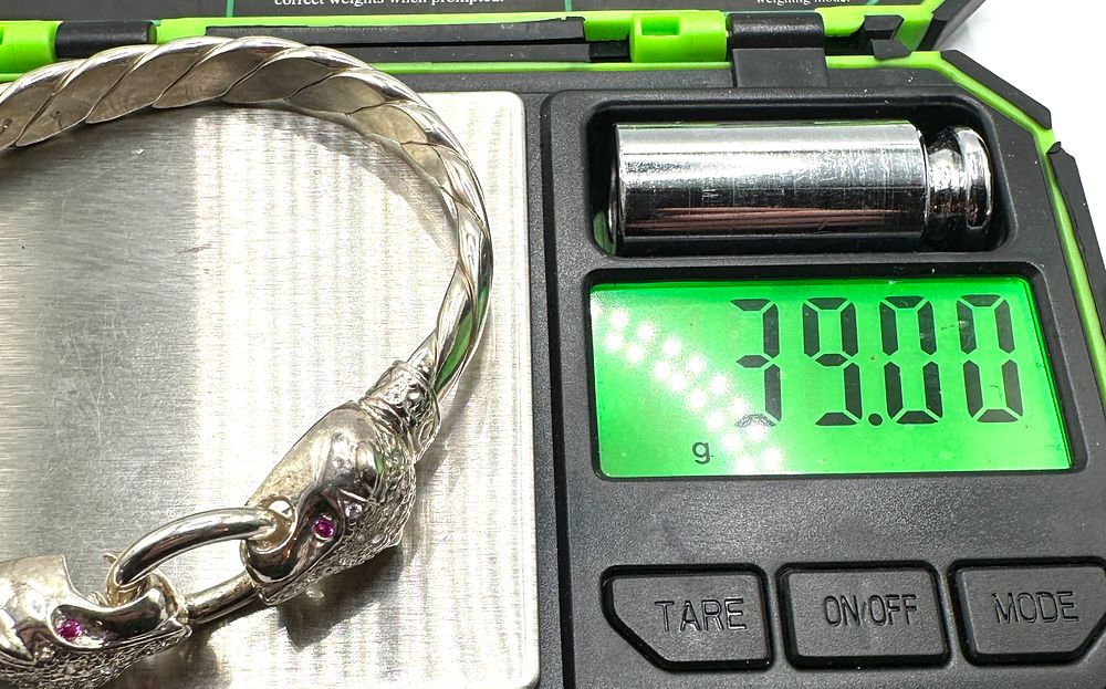 Lot 200: A 925 Sterling Silver Bypass Bangle, Panther Head Terminals