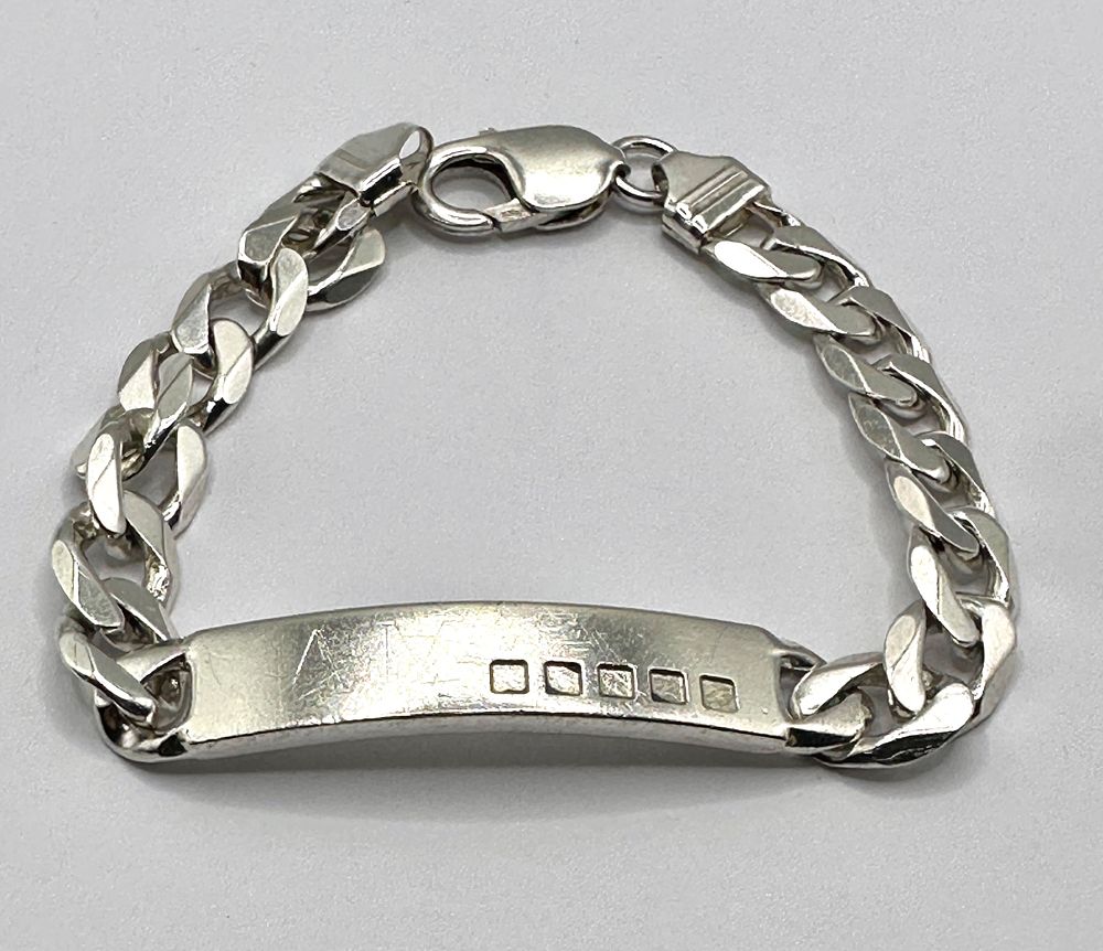 Lot 205: A Sterling Silver Curb Link Identity Bracelet