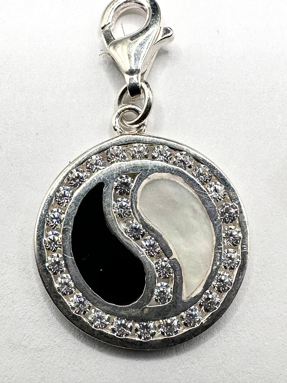 Lot 247: A Sterling Silver Yin Yang Circular Pendant Charm