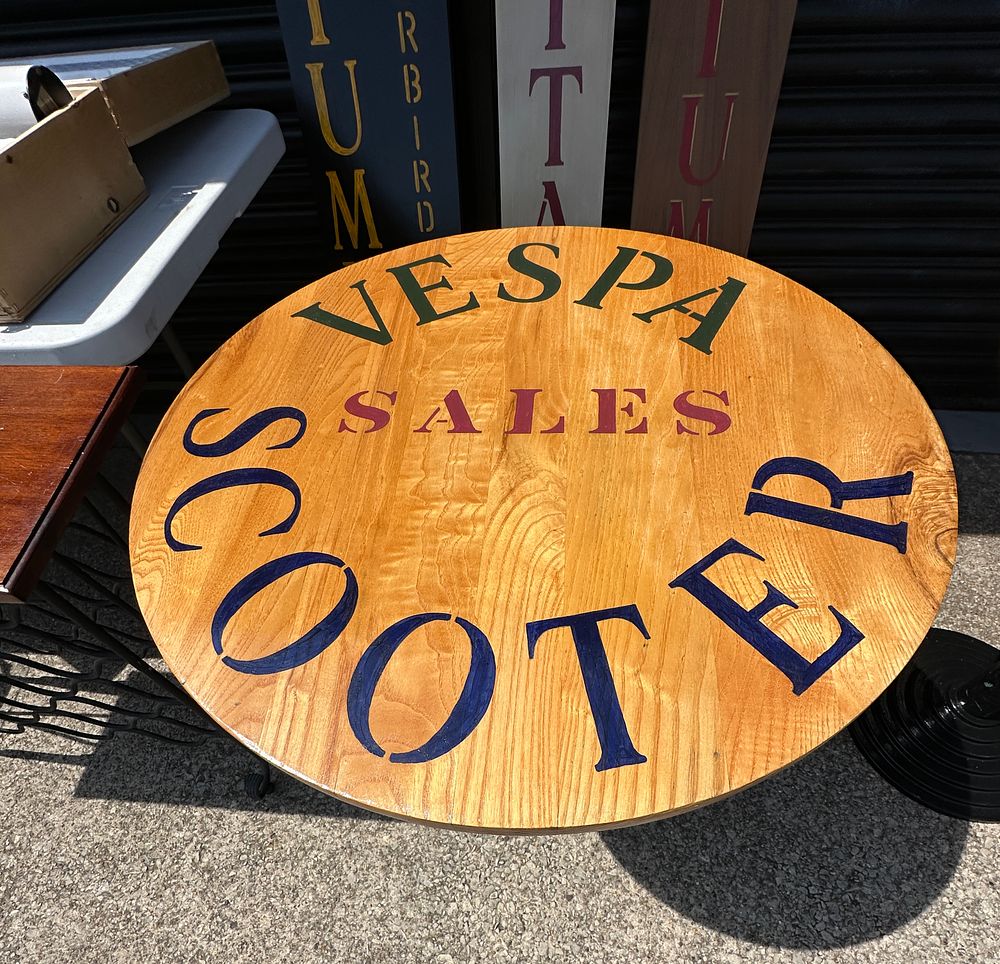 Lot 300: A Pedestal Bistro Table with Vespa Themed Wooden Top