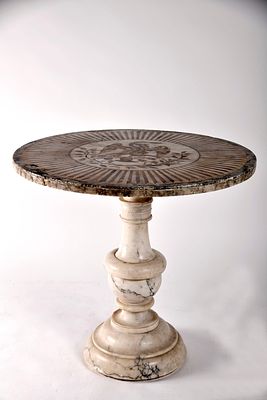 A round table with a central column. pietra dura top in various colours with the symbol of the 